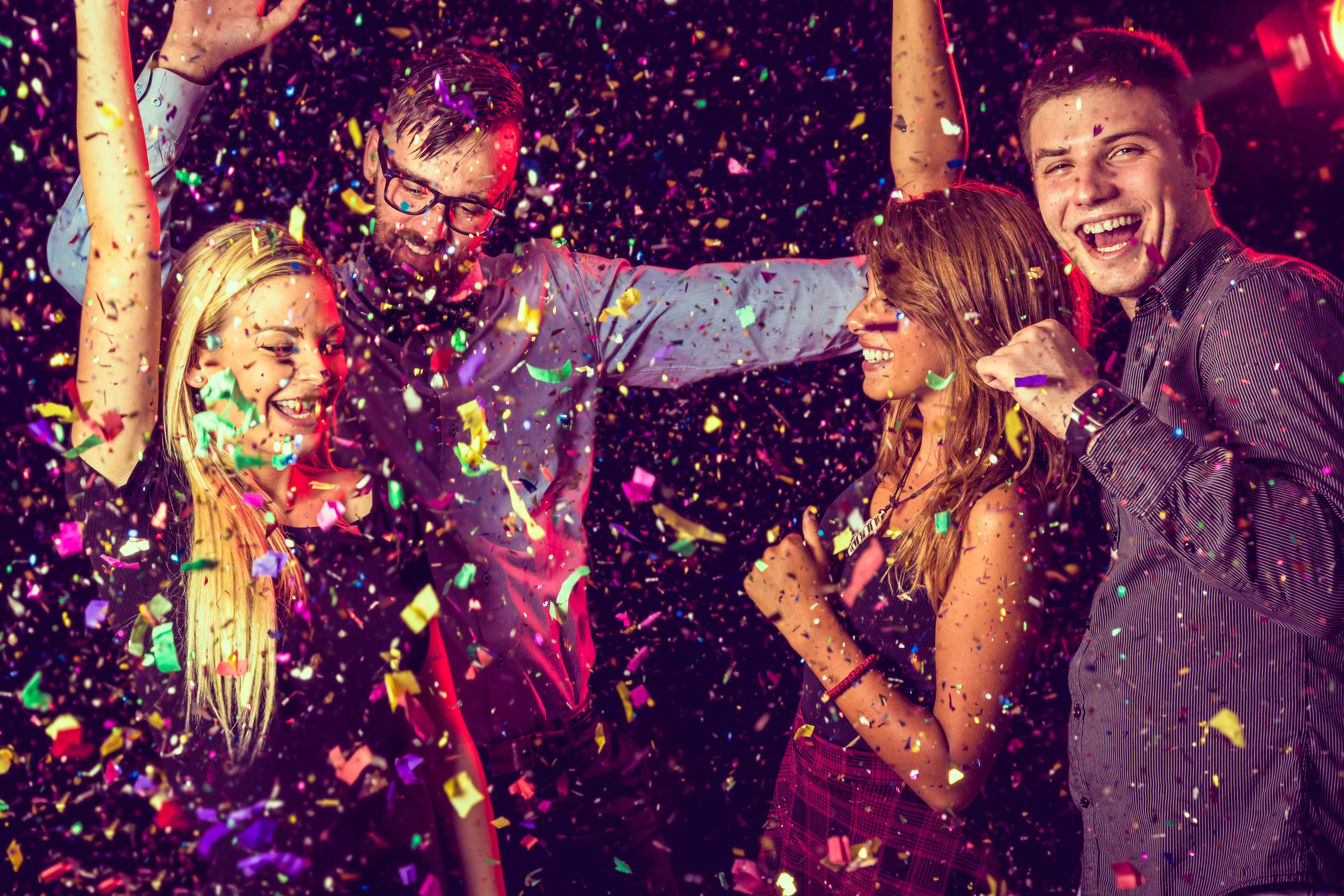 Four young people having fun and dancing at a party