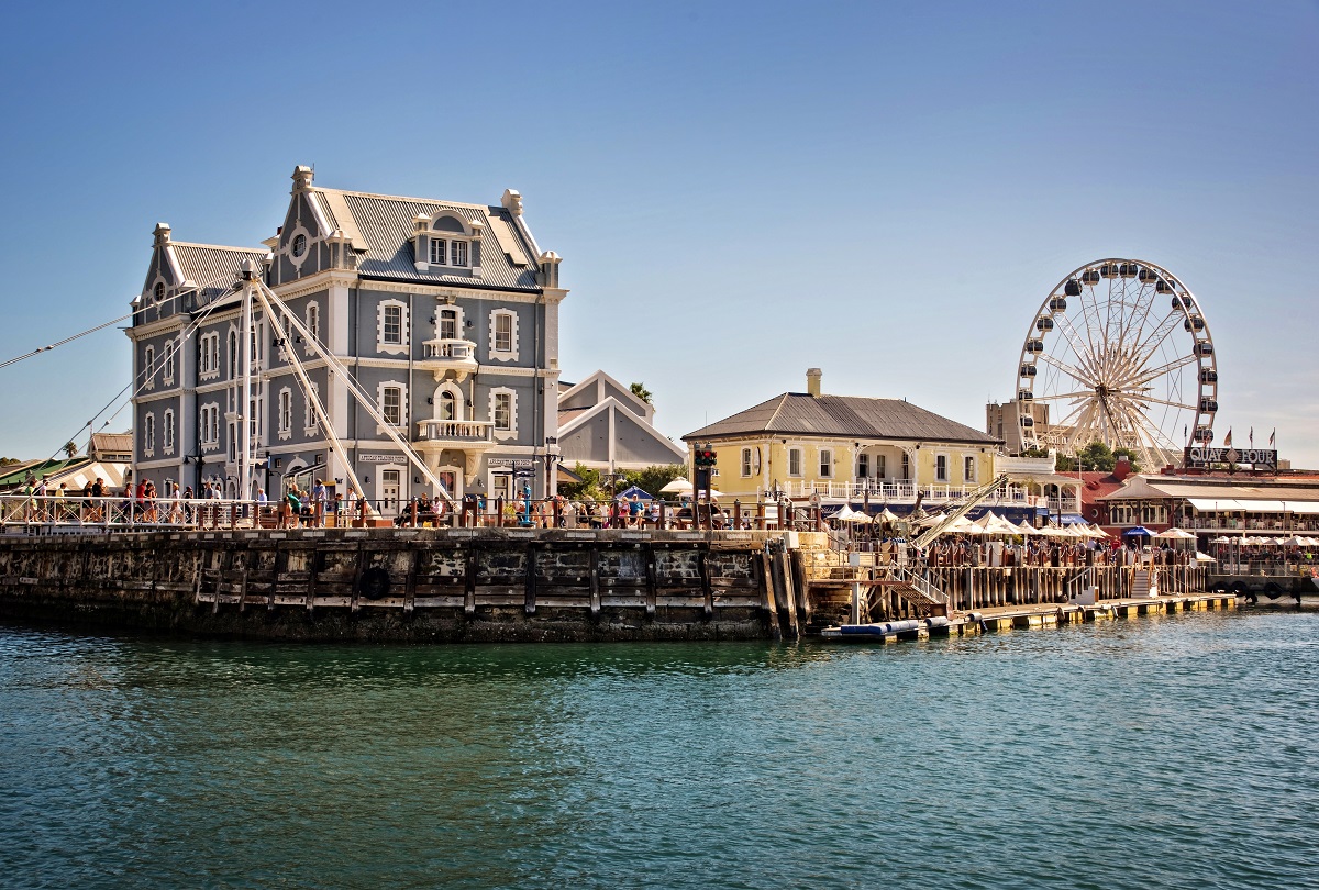 Hafenmauer mit alten Gebäuden und einem Riesenrad.
