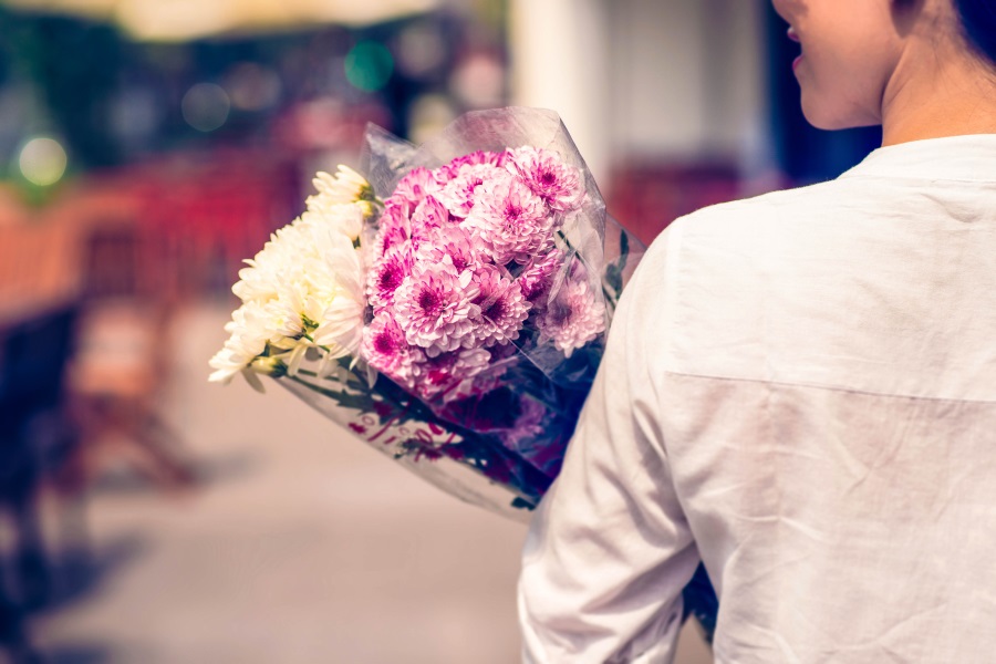 Back view of a woman holding adorable flower bouquets from the shop